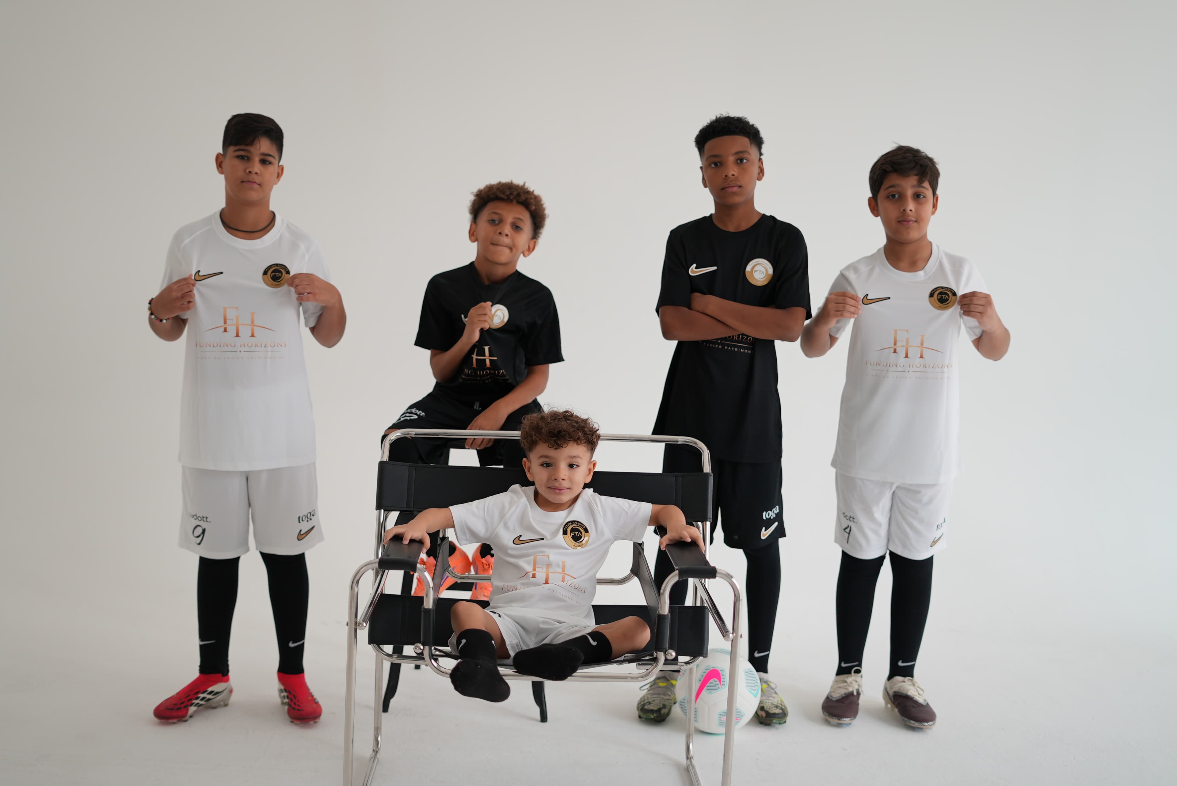 Academy players in FTA kit in the studio, the youngest seated at the centre